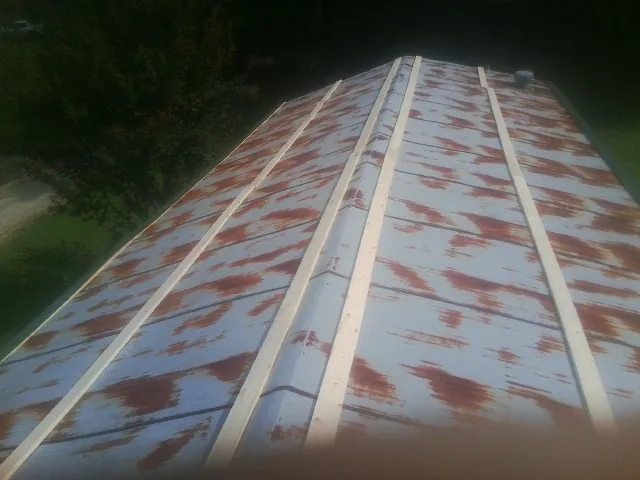 Rusted metal roof panels with new wood purlins before replacement — Storm Damage Roof Repair in Wood Lake by Roofing Brothers