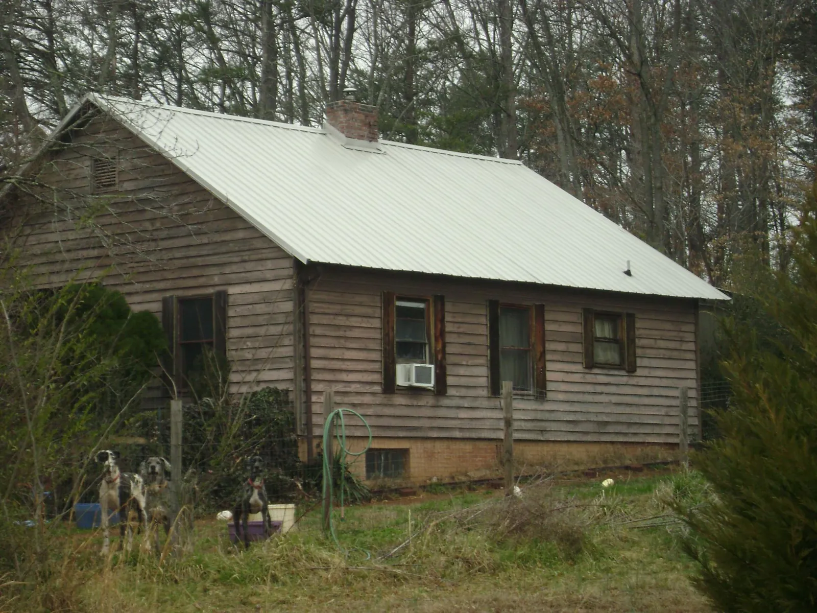 White metal roof on an old wood sided farmhouse, from a Metal Roof Installation job in Wood Lake